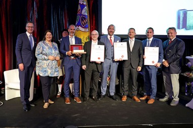 Eine Gruppe von Menschen, die während der Preisverleihung nebeneinander stehen und die Auszeichnungen hochhalten