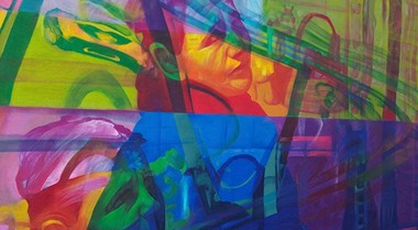 Foto eines abstrakten Kunstwerks, das das Gesicht eines Mannes hinter einer Fläche von verschiedenen Farben zeigt. 