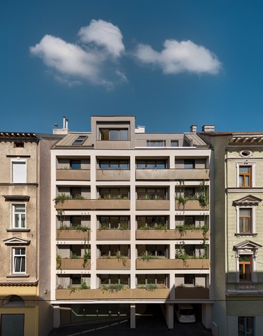 Außenansicht des Gemeindebaus in der Stumpergasse 56. Jedes Stockwerk hat einen begrünten Balkon