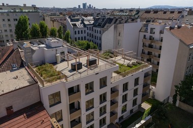 Darstellung eines Gemeindebaus mit modernen, begrünten Fassaden