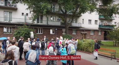 Aufnahme einer Gruppe Wanderer vor einem Gemeindebau