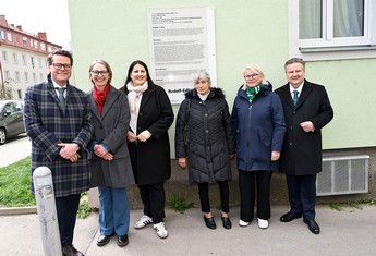 Das Bild zeigt Wohnbaustadträtin Frau Gaal sowie Bürgermeister Michael Ludwig und 4 andere Personen in Winterkleidung vor einer Hauswand stehend.