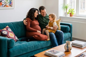 Ein KI-generiertes Foto von einer Familie, die auf einer Couch sitzt.