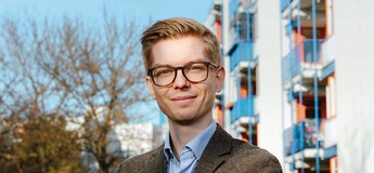 Das Foto zeigt einen einen jungen Mann im Gespräch mit einer Dame