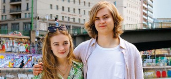 Foto von einem jungen Mann und einer jungen Frau, die Arm in Arm am Wiener Donaukanal stehen