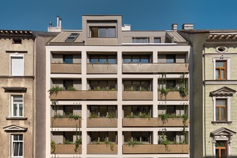 Außenansicht des Gemeindebaus in der Stumpergasse 56. Jedes Stockwerk hat einen begrünten Balkon