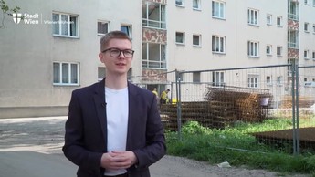 Foto einer Person vor einem Gemeindebau, der aktuell saniert wird