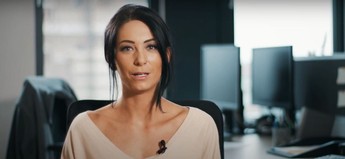 Eine Frau im Büro die zur Kamera blickt und redet 