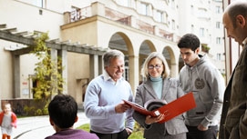 Mehrere Mieterinnen und Mieter treffen im Gemeindebauhof zusammen und diskutieren.