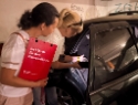 2 Frauen schauen sich ein demoliertes Auto an und begutachten die Situation.